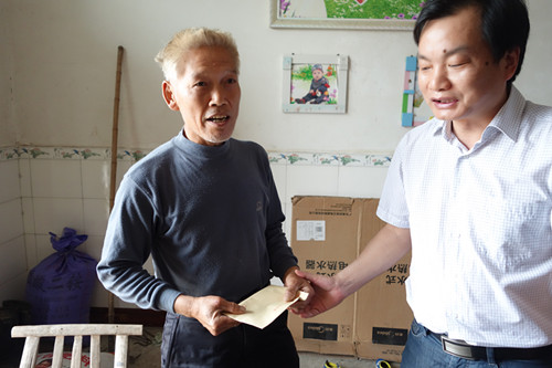 图为市法院院长袁溥（右）为帮扶对象送去慰问金。.JPG